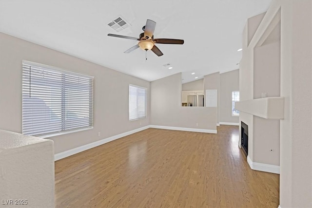 unfurnished living room with hardwood / wood-style flooring, ceiling fan, and lofted ceiling