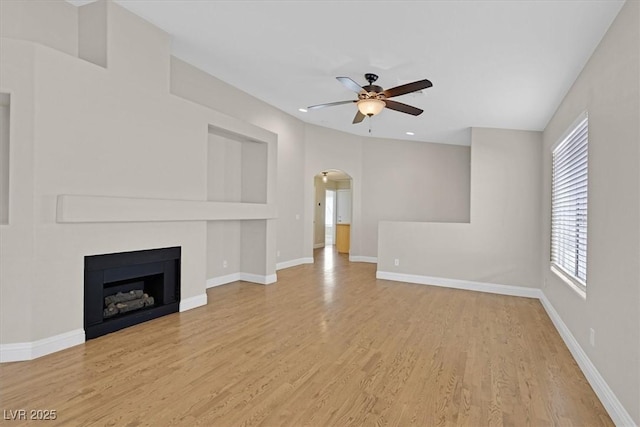 unfurnished living room featuring ceiling fan and light wood-type flooring