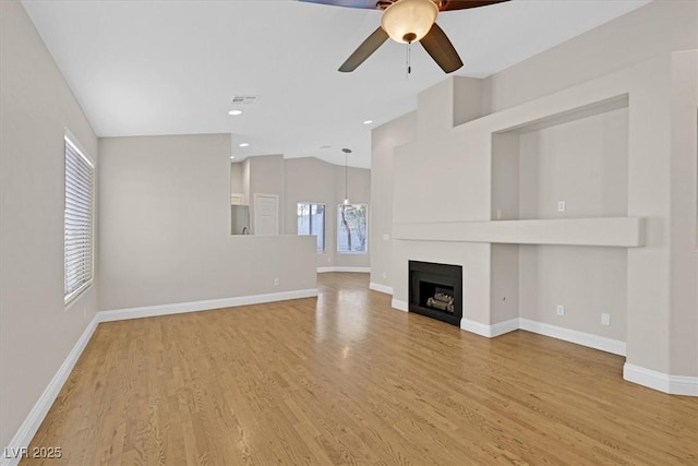 unfurnished living room with ceiling fan, lofted ceiling, and light hardwood / wood-style floors