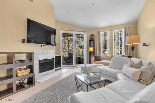 living room featuring lofted ceiling, a fireplace, and light carpet