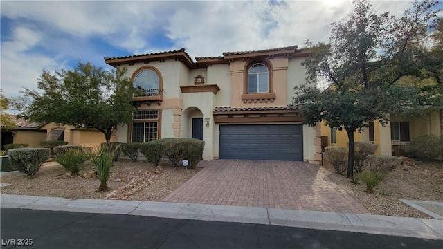 mediterranean / spanish house featuring a garage and a balcony