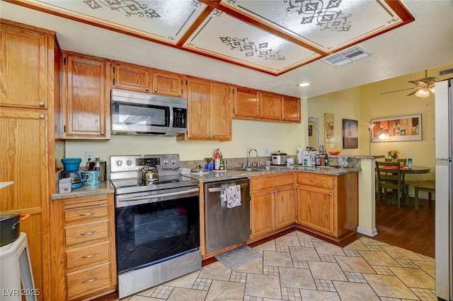 kitchen featuring stainless steel appliances, sink, ceiling fan, and kitchen peninsula