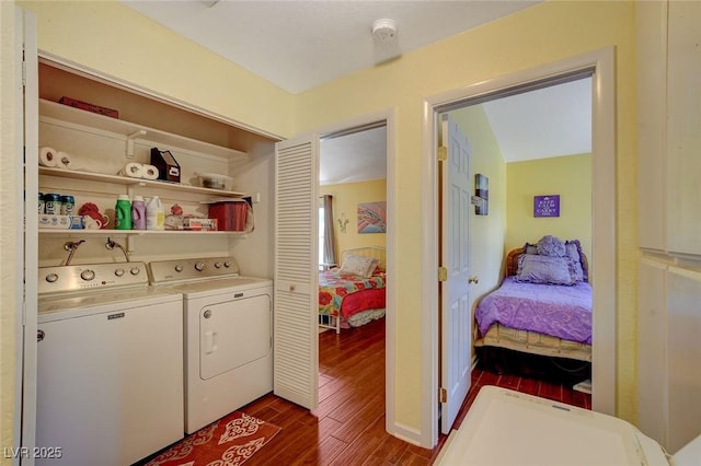 clothes washing area with dark wood-type flooring and washing machine and clothes dryer