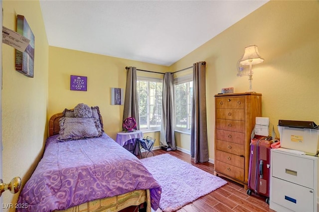 bedroom with wood-type flooring and lofted ceiling