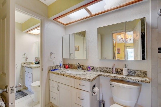 bathroom with vanity, tile patterned flooring, and toilet