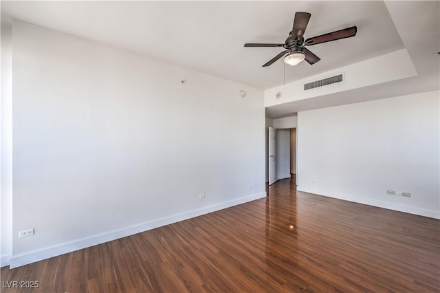 spare room featuring dark wood-type flooring and ceiling fan