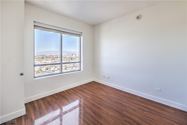 unfurnished room with dark wood-type flooring and plenty of natural light