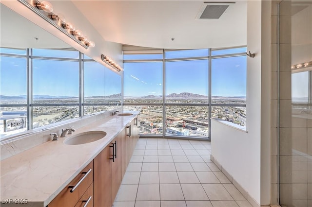 bathroom with tile patterned flooring, vanity, a mountain view, and floor to ceiling windows