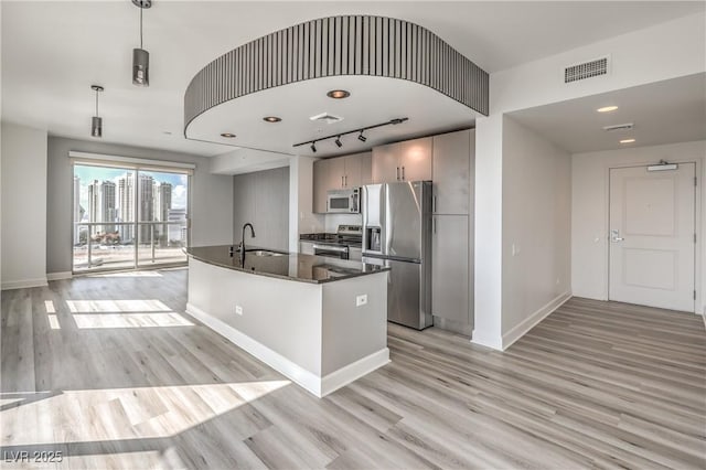 200 W Sahara Ave Unit 2108, Las Vegas, NV 89102 - kitchen with stainless steel appliances, baseboards, light wood-style flooring, a sink, and an island with sink