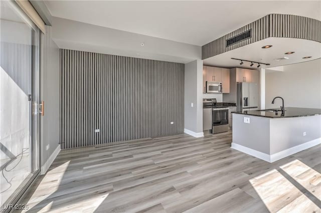 200 W Sahara Ave Unit 2108, Las Vegas, NV 89102 - kitchen featuring stainless steel appliances, dark countertops, a sink, light wood-style floors, and baseboards