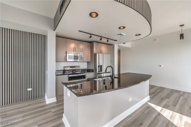200 W Sahara Ave Unit 2108, Las Vegas, NV 89102 - kitchen featuring stainless steel appliances, a sink, light wood-style floors, and a center island with sink