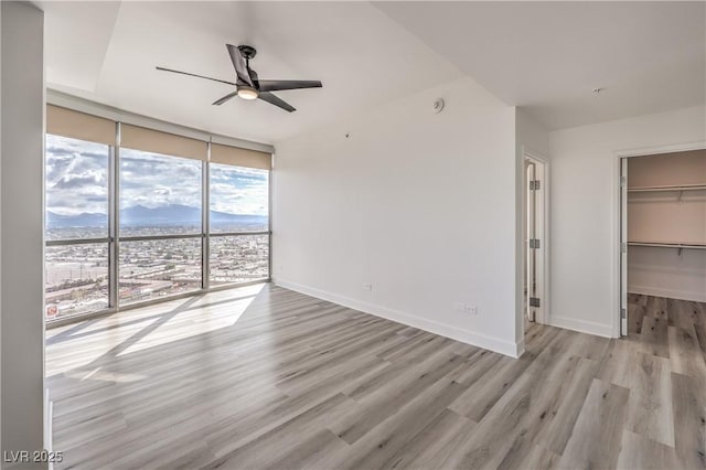 200 W Sahara Ave Unit 2108, Las Vegas, NV 89102 - unfurnished living room featuring floor to ceiling windows, a ceiling fan, light wood-style flooring, and baseboards