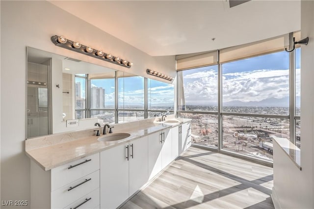 200 W Sahara Ave Unit 2108, Las Vegas, NV 89102 - full bathroom with wood finished floors, a wall of windows, double vanity, and a water and mountain view