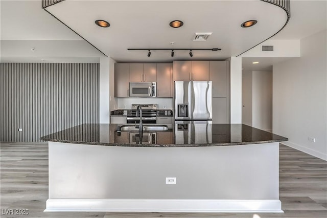 200 W Sahara Ave Unit 2108, Las Vegas, NV 89102 - kitchen featuring stainless steel appliances, a sink, light wood-type flooring, dark stone counters, and recessed lighting