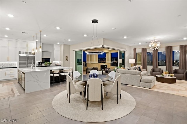 dining space with light tile patterned flooring and a notable chandelier