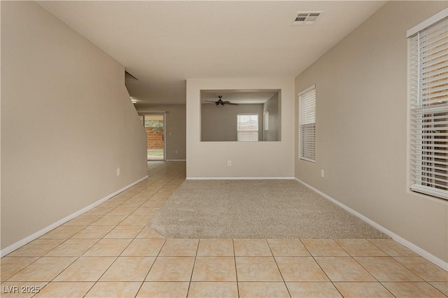 tiled spare room featuring ceiling fan