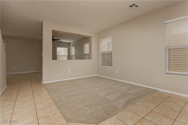 tiled spare room featuring ceiling fan