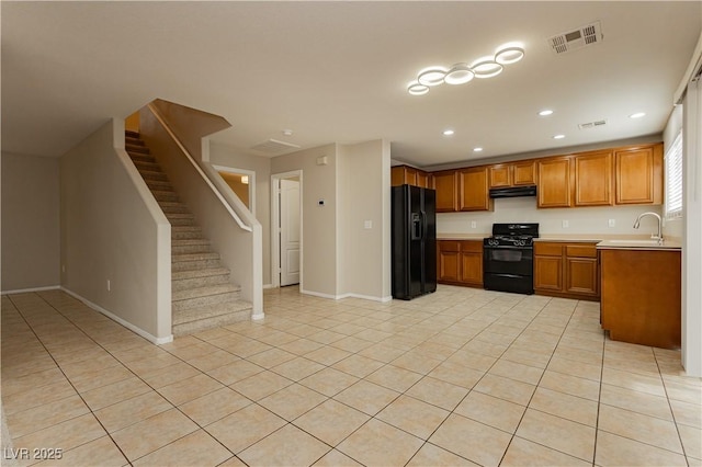 kitchen featuring sink, light tile patterned floors, and black appliances