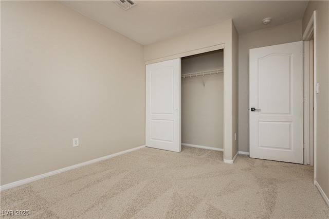 unfurnished bedroom featuring a closet and light carpet