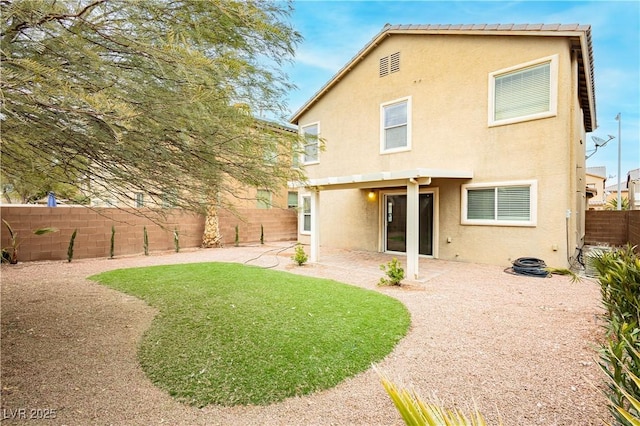 rear view of house featuring a patio area and a lawn