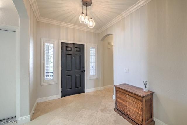 foyer with crown molding and a chandelier