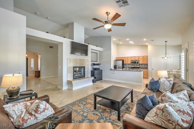 living room with ceiling fan, a fireplace, and high vaulted ceiling