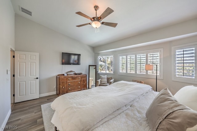 bedroom with ceiling fan, lofted ceiling, and wood-type flooring