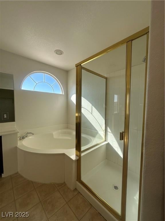 bathroom with plus walk in shower, tile patterned floors, and a textured ceiling