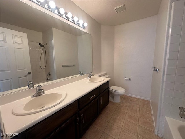 full bathroom with vanity, tiled shower / bath, tile patterned floors, and toilet