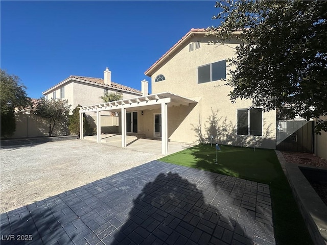 rear view of house with a pergola and a patio