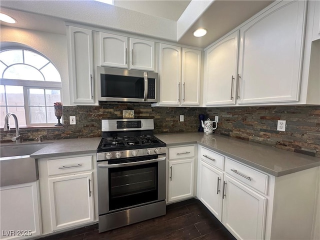 kitchen featuring tasteful backsplash, sink, stainless steel appliances, and white cabinets