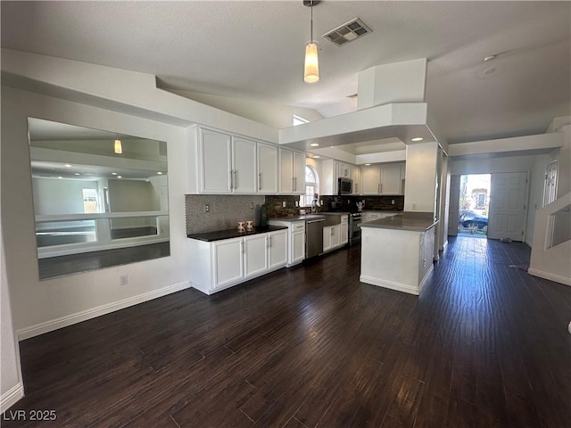 kitchen featuring dark wood-type flooring, a wealth of natural light, white cabinets, and backsplash