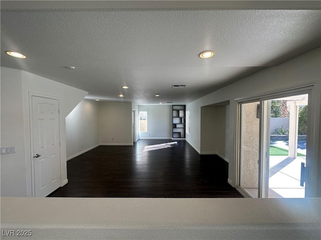 unfurnished room featuring dark hardwood / wood-style floors and a textured ceiling