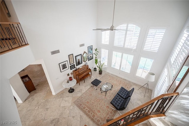 living room with a towering ceiling and ceiling fan