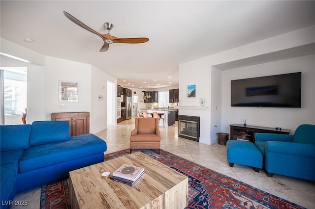 tiled living room featuring ceiling fan, sink, and a healthy amount of sunlight