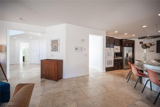 kitchen featuring white appliances and dark brown cabinetry