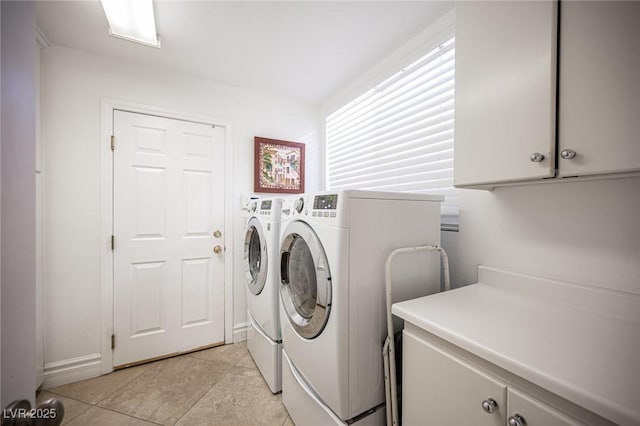 laundry room with separate washer and dryer and cabinets