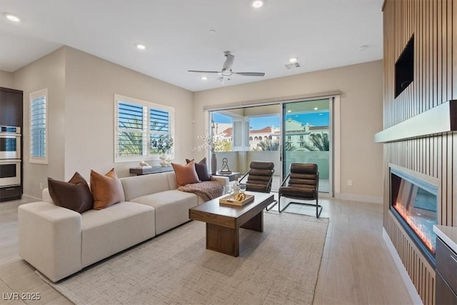 living room with ceiling fan and light hardwood / wood-style floors