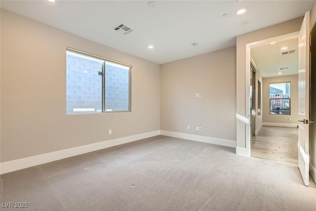 spare room featuring recessed lighting, visible vents, baseboards, and light colored carpet