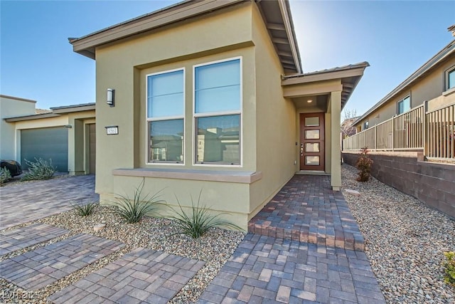 view of front facade featuring fence and stucco siding