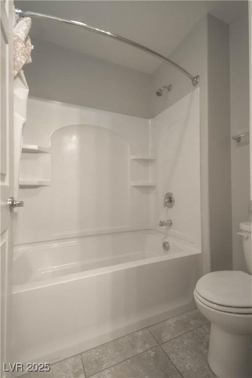 bathroom featuring tile patterned flooring, bathing tub / shower combination, and toilet