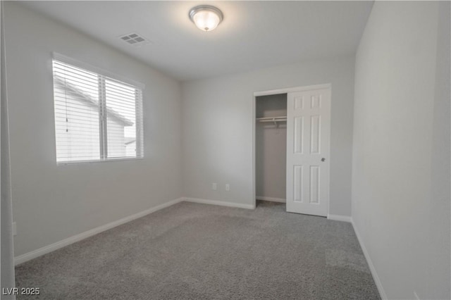 unfurnished bedroom featuring carpet flooring and a closet