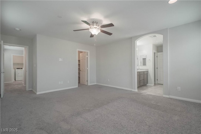 unfurnished room with ceiling fan, light colored carpet, and washing machine and dryer