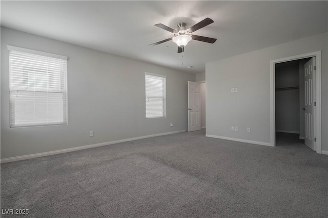 unfurnished bedroom featuring a spacious closet, ceiling fan, and carpet flooring