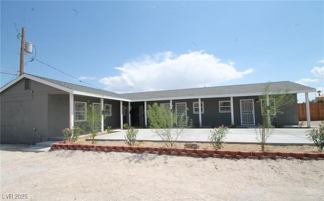 view of front facade with fence and stucco siding