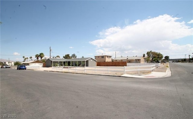 view of front of property with a residential view and fence