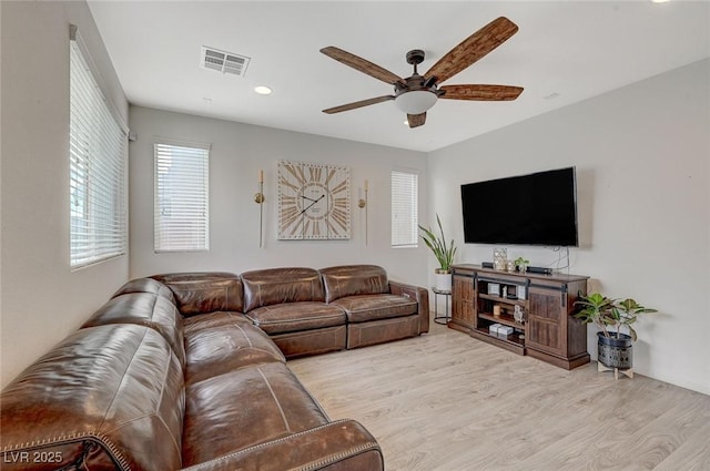 living room featuring light hardwood / wood-style flooring and ceiling fan