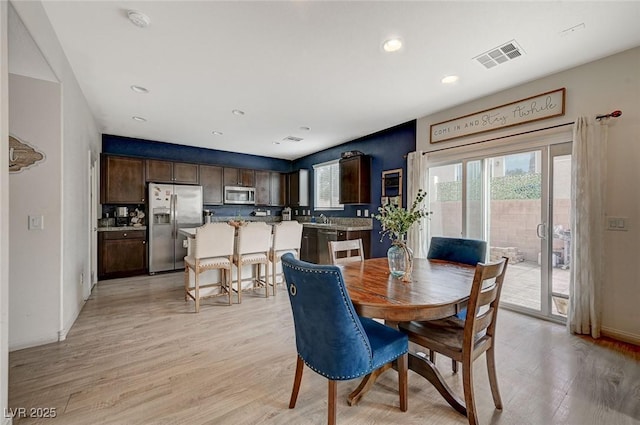 dining area with sink and light hardwood / wood-style flooring