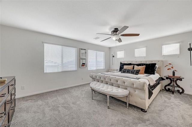 bedroom featuring ceiling fan, multiple windows, and light carpet