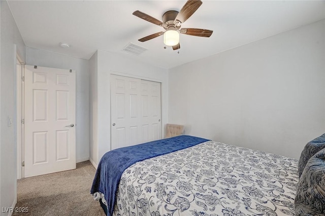 bedroom with ceiling fan, a closet, and light carpet